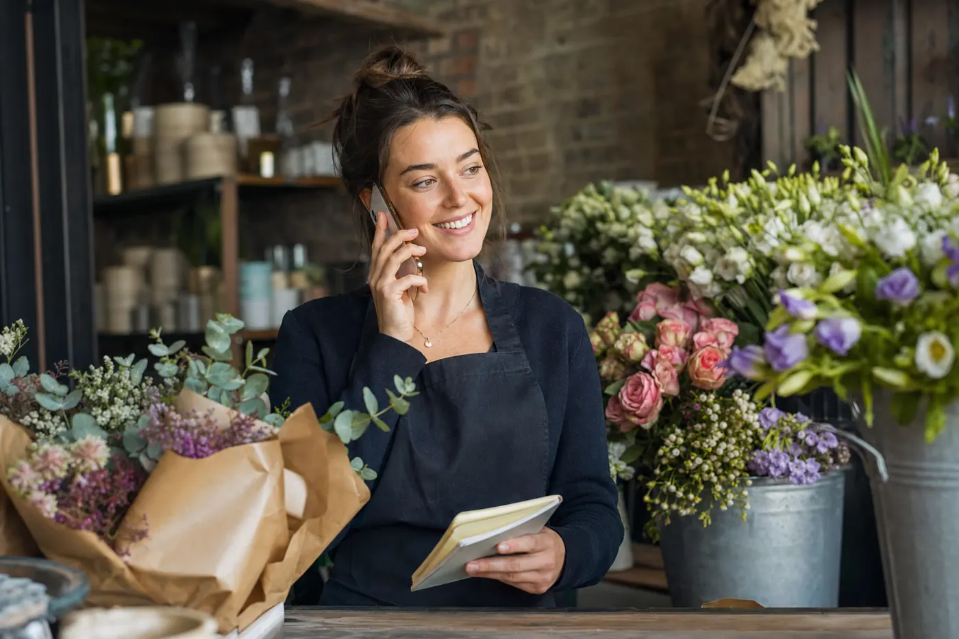 Florist taking an enquiry call in her flower shop
